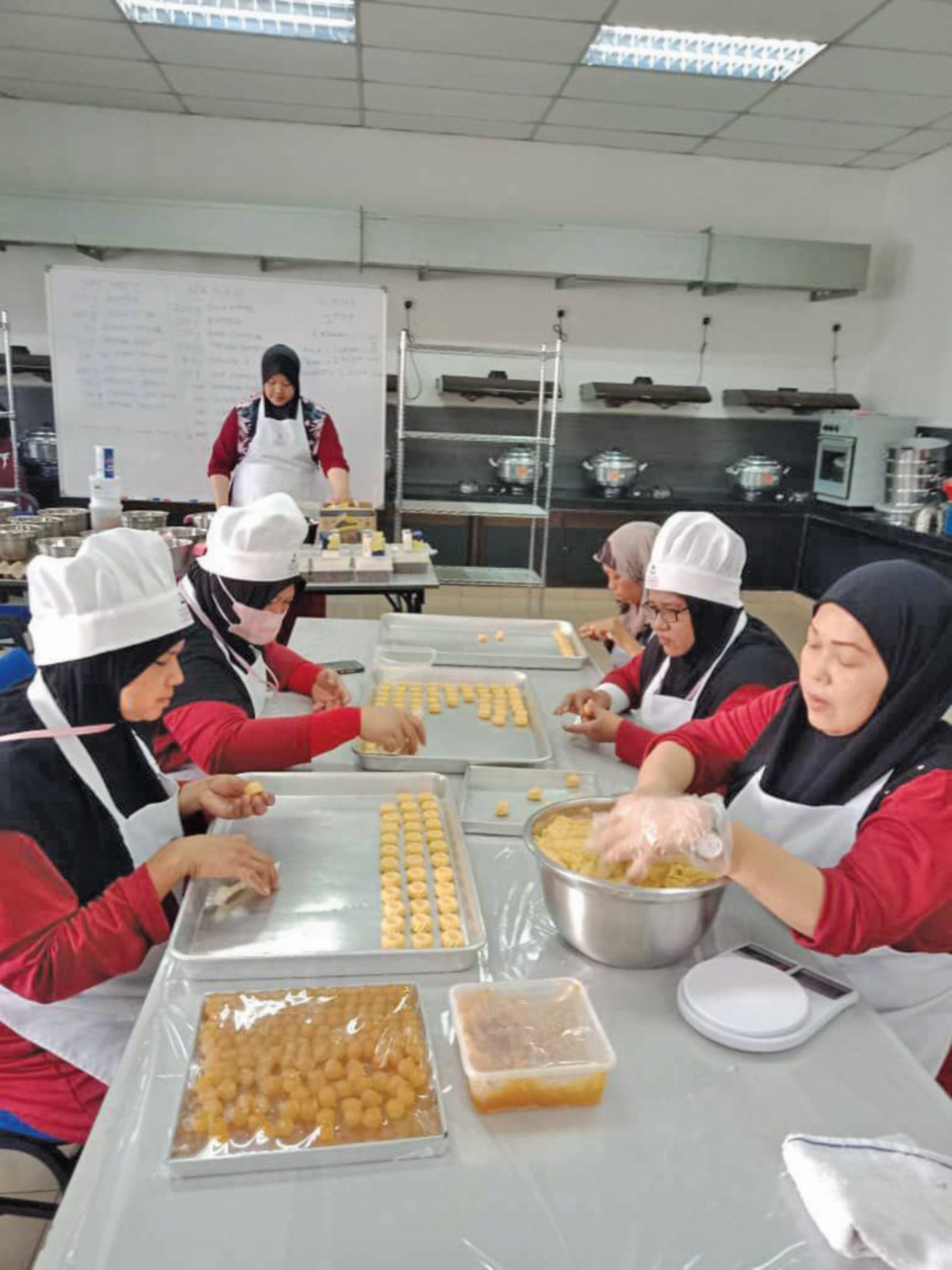 PESERTA bengkel membuat kek dan tart menunjukkan hasil produk dan bergambar bersama panel ketika pembentangan hasil kerja di Danga Bay.