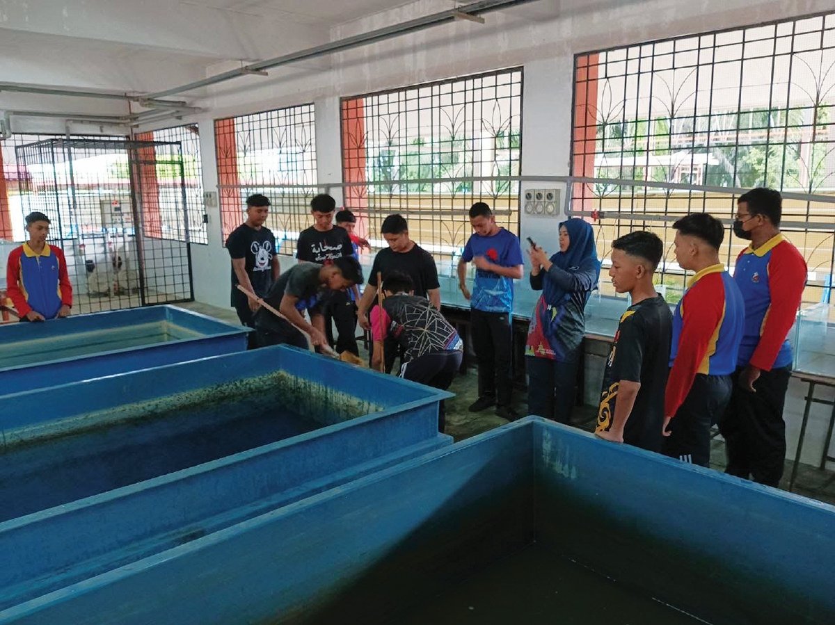 PELAJAR membersihkan sekitar kolam ternakan ikan yang juga satu daripada pembelajaran dalam mata pelajaran AHR.