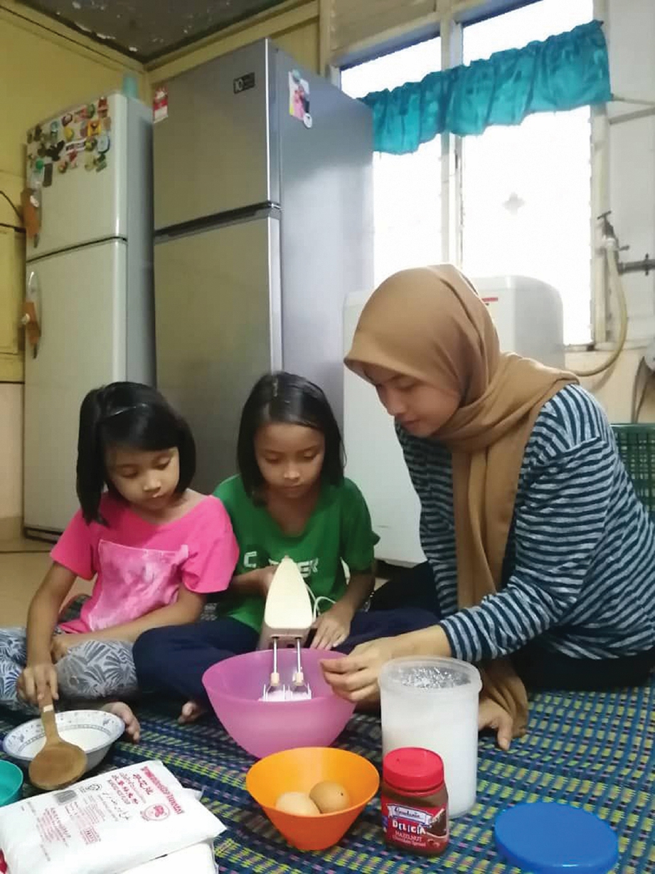 AZRINA membantu anak-anaknya membuat kek. 