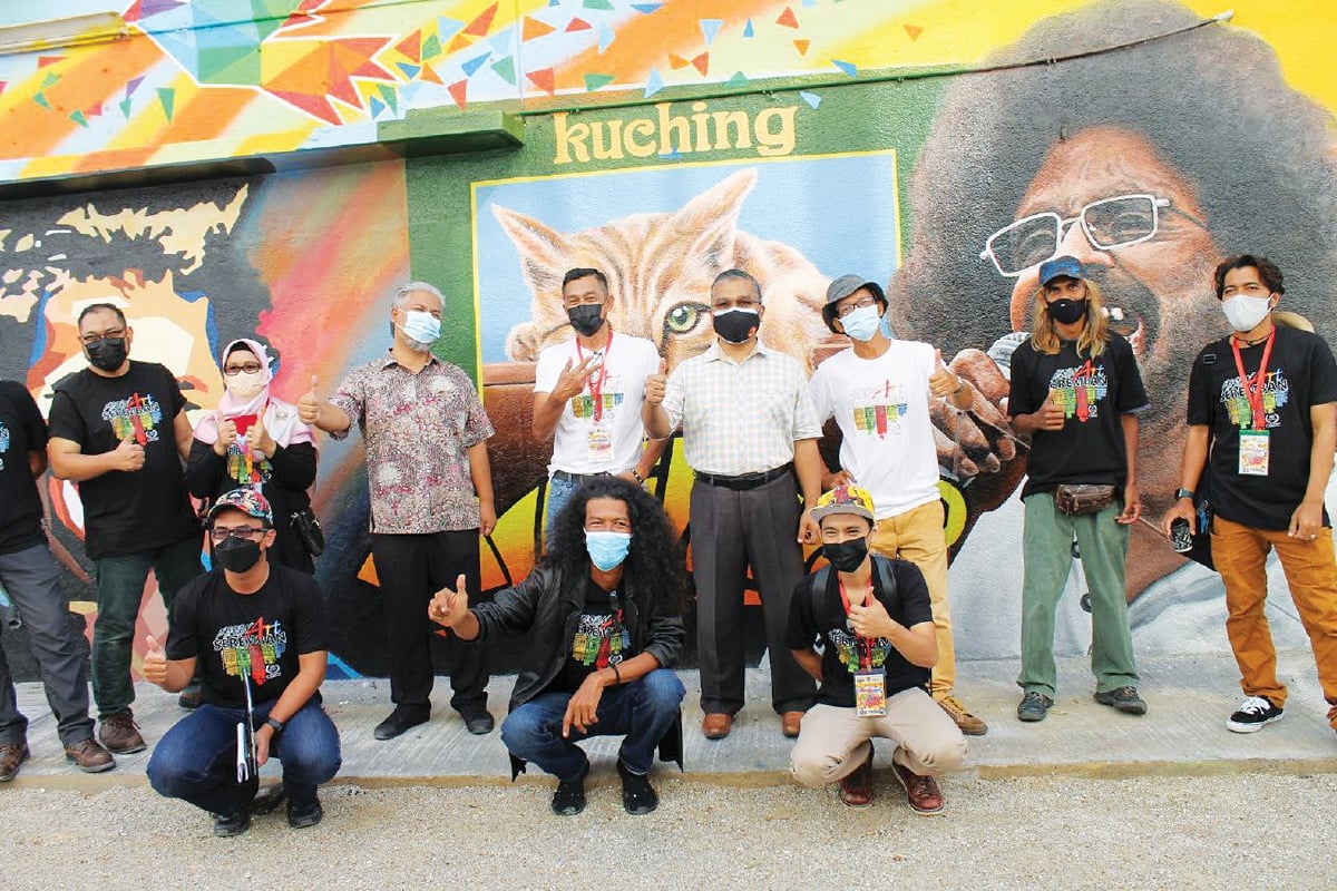 MASRI (tengah) bersama pelukis mural.