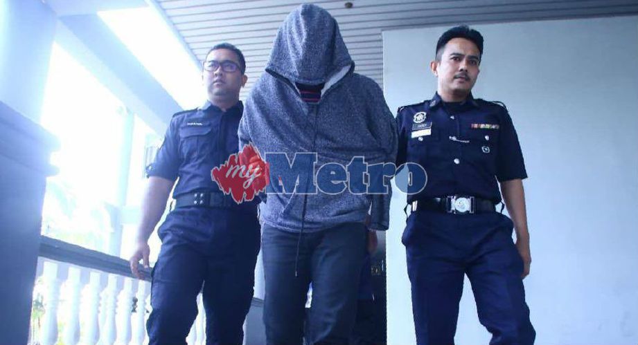 TERTUDUH Mohd Khairulnizam Shaari, 32, diiringi anggota polis selepas mengaku tidak bersalah atas dakwaan mencekik leher dan menumbuk muka isterinya. Foto Zuhairi Zuber