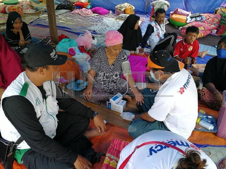 Rawatan perubatan diberikan doktor Mercy Malaysia kepada mangsa yang berlindungi di khemah sementara di Palu. FOTO NSTP
