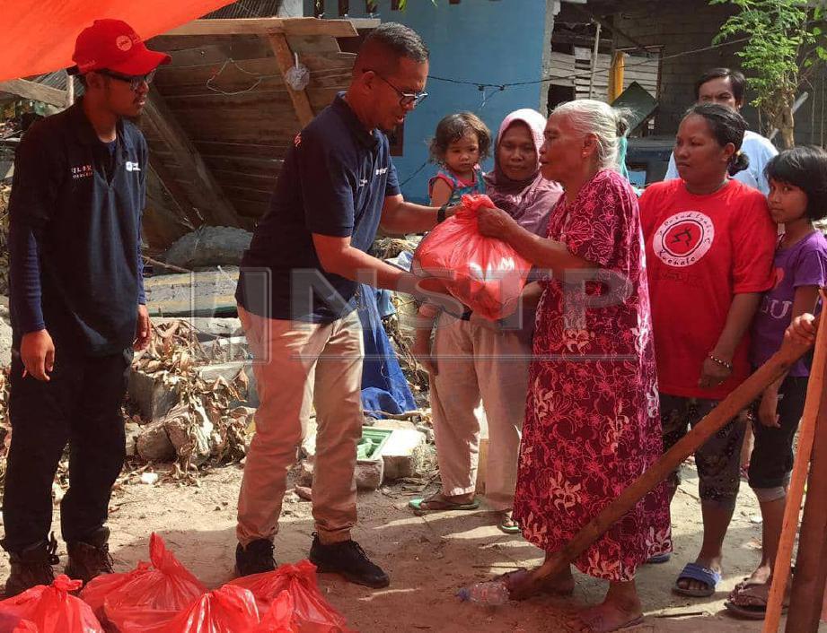 SUKARELAWAN Mercy Malaysia menyampaikan sumbangan makanan kepada mangsa gempa bumi di Desa Silae, Palu. FOTO NSTP