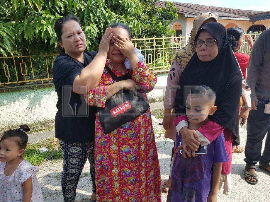 AGUS Tina Indayati Yatim, 34, (dua dari kiri) tidak dapat menahan sebak selepas rumah sewanya terbakar. FOTO Nurul hidayah Bahaudin/Bomba