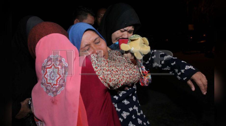 Soliah ditenangkan saudaranya ketika pengebumian Siti Masitah di Perkuburan Islam Tanjung Mendang, Pekan. FOTO Muhd Asyraf Sawal