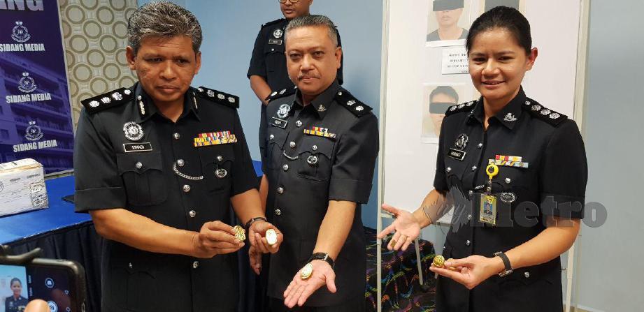 KETUA Polis Daerah Serdang Asisten Komisioner Ismadi Borhan (kiri) menunjukkan ketulan emas palsu yang dirampas dalam serbuan itu.