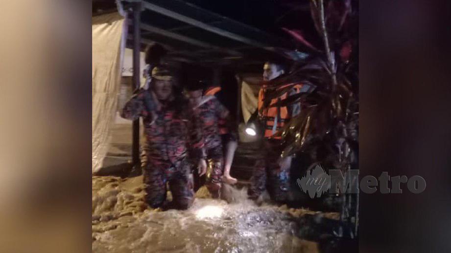 ANGGOTA bomba memindahkan mangsa di Kampung Bendang Sira yang dilanda banjir kilat. FOTO Ihsan Bomba