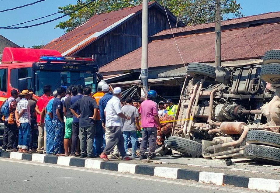 ANGGOTA bomba berusaha mengeluarkan mangsa yang tersepit dalam lori simen yang terbalik dalam kemalangan di Pekan Langgar. FOTO Zuliaty Zulkiffli