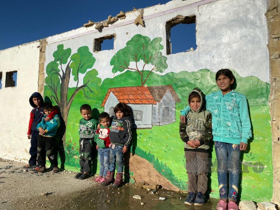  Kanak-kanak pelarian di Kem Al-Awdah di Lembah Beqaa mengabdikan lukisan mural ditembok kem berkenaan bagi melepaskan kerinduan terhadap kampung halaman. FOTO Hafidzul Hilmi Mohd Noor