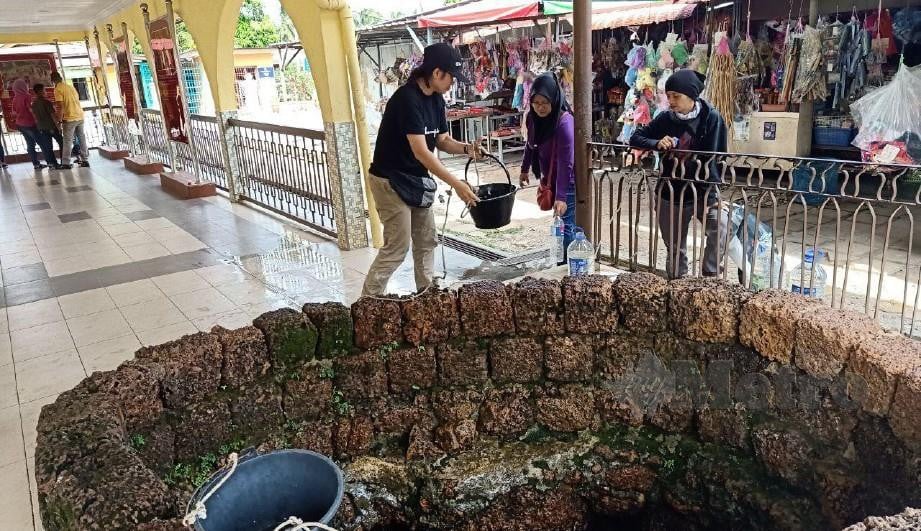 ORANG ramai mengambil air perigi Hang Tuah di kampung Duyong. FOTO NAZRI ABU BAKAR