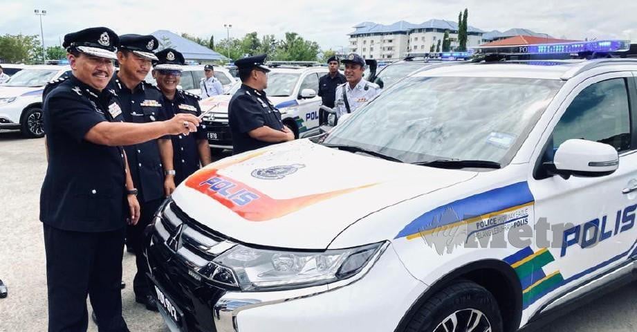 ZAINI (kiri) merasmikan menyerahkan kenderaan baru di Padang Kawad Ibu Pejabat Kontinjen (IPK) Sabah, Kota Kinabalu.