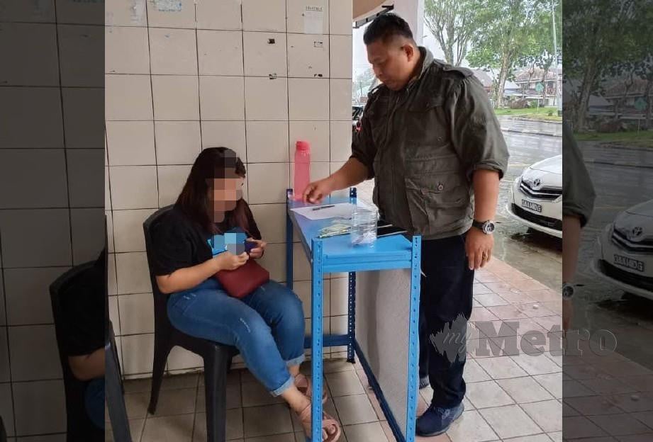 SEORANG wanita yang ditahan kerana menjual loteri haram di kaki lima Pusat Penjaja Bau. FOTO MELVIN JONI