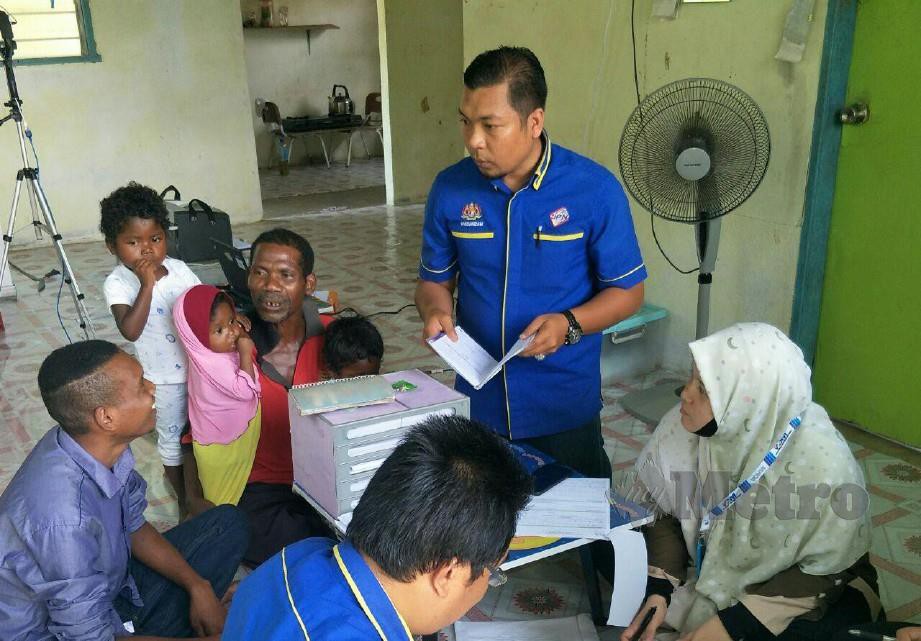 PEGAWAI JPN Kelantan membuat pendaftaran sijil kelahiran kanak-kanak Orang Asli Batek di Kampung Aring 5, kelmarin. Pix STR RAMLI IBRAHIM