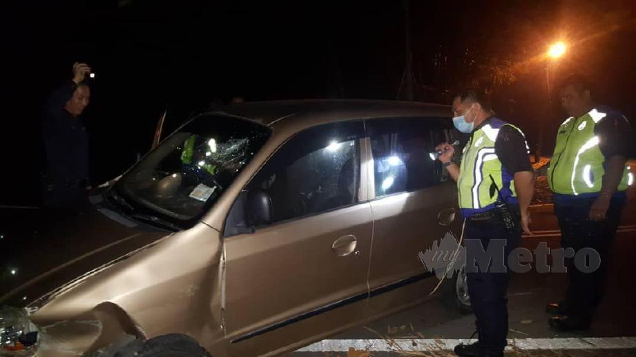 Pegawai dan anggota polis memeriksa kereta yang dipandu suspek selepas terbabas di satu selekoh tajam di di Jalan Bukit Bendera, Kota Kinabalu.- FOTO Juwan Riduan