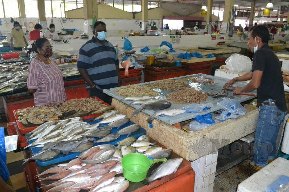 Pelanggan melihat ikan dan udang yang dijual di Pasar Besar Kuantan, Kuantan. FOTO Asrol Awang
