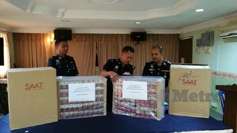 AZMIR Damiri (tengah) menunjukkan dua kotak besar mengandungi 1,000 kotak rokok seludup di Balai Polis Ibu Pejabat (IPD) Pasir Puteh. FOTO  Ihsan pembaca