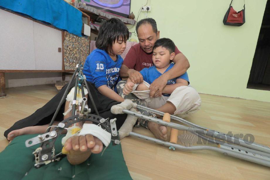 Sarih bersama anaknya Syarifah dan Sarih Mohamad yang mengalami cacat kekal selepas terbabit dengan kemalangan maut tahun lalu yang mengorbankan isteri dan seorang lagi anaknya di Jalan Rompin-Tanjung Gemok. FOTO MOHD RAFI MAMAT