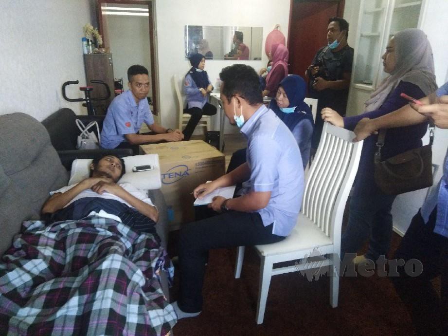 Pegawai Perkeso sambil disaksikan Pengarah Perkeso Terengganu Farihah Che Husin (duduk empat kiri) melakukan proses dokumentasi ketika mengunjungi Azlan di kediamannya di Pangsapuri  Ladang Tok Pelam. FOTO ZAID SALIM