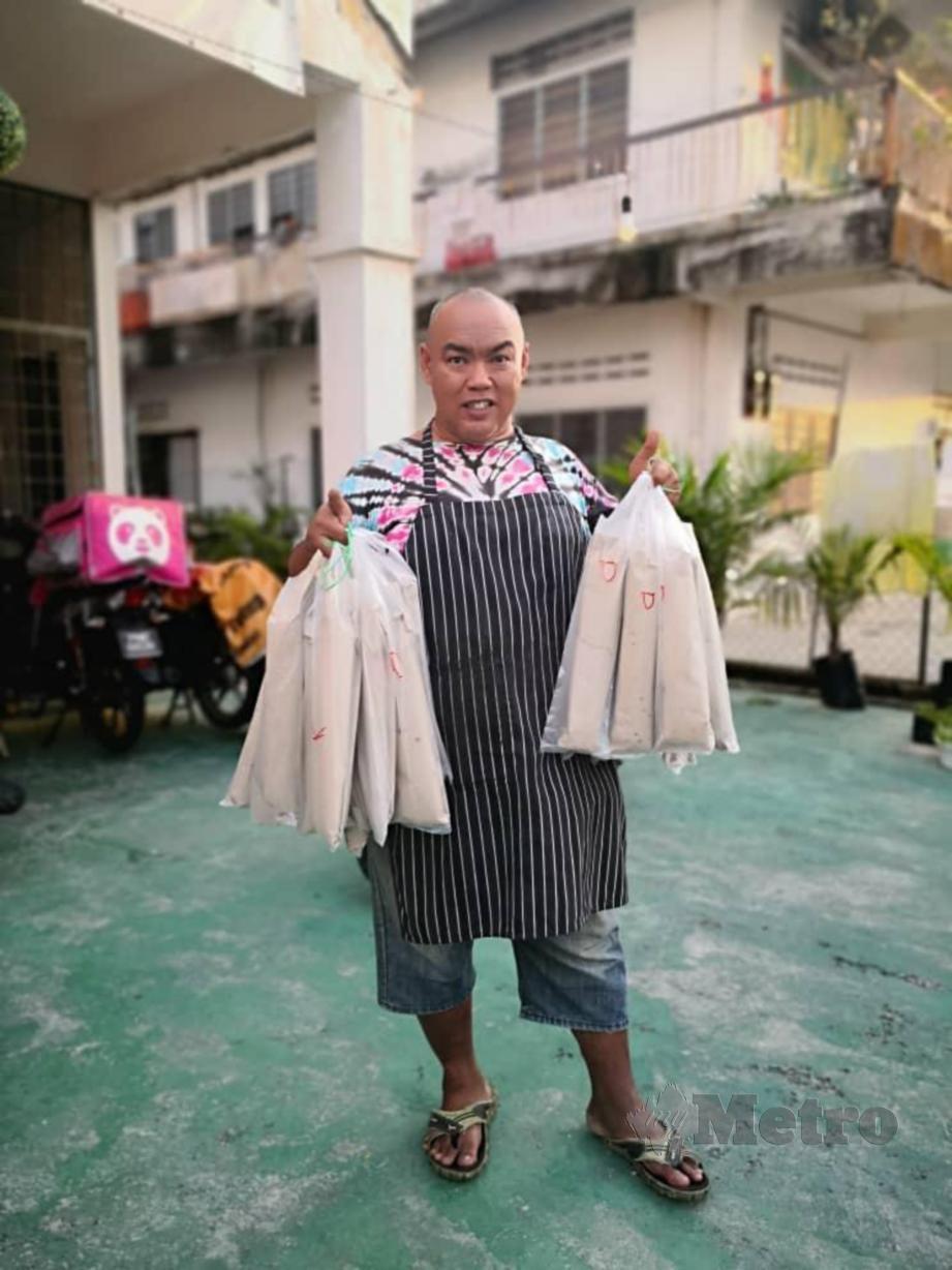 Safizan Yakin, 45, mengedarkan 25 bungkusan roti john kepada pasukan barisan hadapan yang bertugas di kawasan berhampiran Pasar Jalan Othman yang dikenakan PKPD. FOTO Ihsan Safizan Yakin