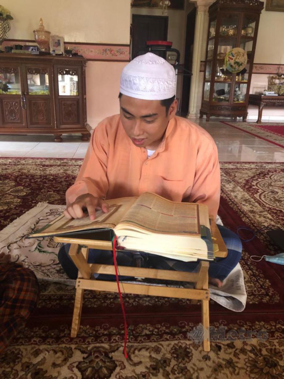 Woo Sheng Xiang atau nama Islamnya Ahmad Fauzan Woo Abdullah membaca al-Quran di rumah gurunya selepas memeluk Islam sejak lebih sebulan lalu. FOTO Zah Mohamad