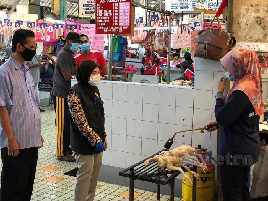 FAUZI Sharif (kiri) melakukan pemantauan harga ayam di Pasar Besar Alor Setar yang meningkat sejak seminggu lalu. FOTO ZULIATY ZULKIFFLI