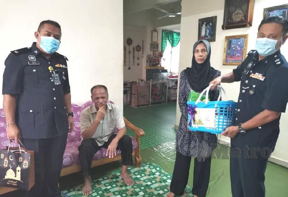 Mohd Khairiel Mohd Arif (kanan) menyerahkan sumbangan kepada keluarga Sarjan Mejar Jamari Idris ketika melawat anggota berkenaan di Kuarters IPD Jempol.