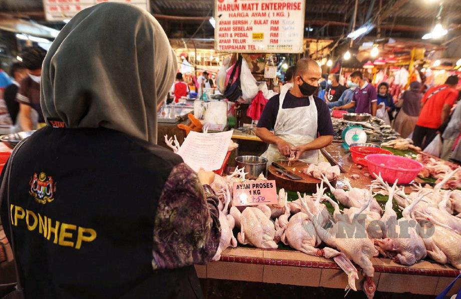 Pegawai Pemantau Harga KPDNHEP, Siti Zaida memberi senarai harga kawalan perayaan Aidilfitri kepada peniaga-peniaga di Pasar Datuk Keramat ketika tinjauan harga maksimum harga barang yang berkuat kuasa hari ini hingga 3 Jun 2020. FOTO MOHD YUSNI ARIFFIN