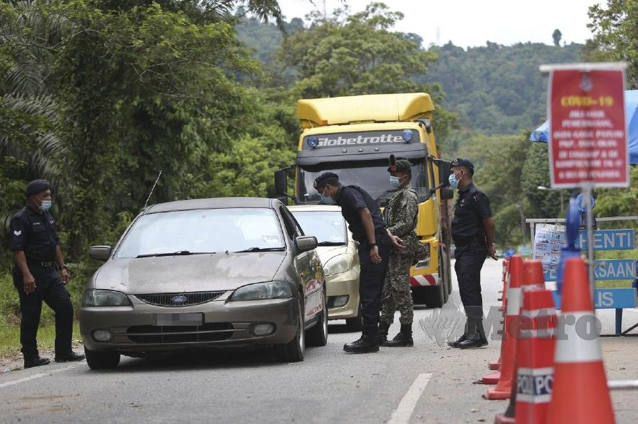 Polis dan ATM memeriksa dokumen perjalanan rentas negeri di SJR Kampung Basung. 