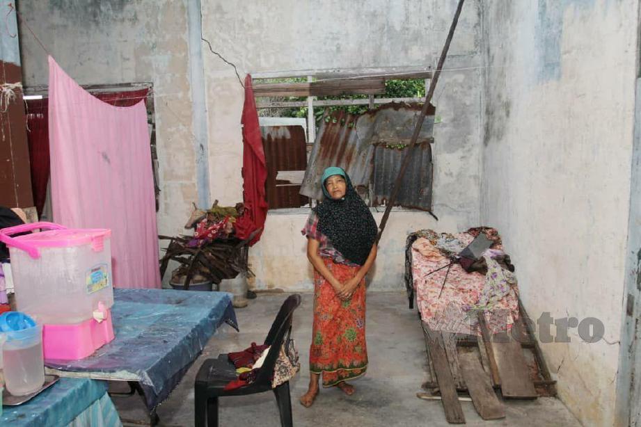 Wan Aisyah Jaafar, 59, yang menghidap halusinasi lebih 10 tahun menunjukkan keadaan rumahnya di Kampung Che Deris di sini yang sangat uzur. FOTO SITI ROHANA IDRIS