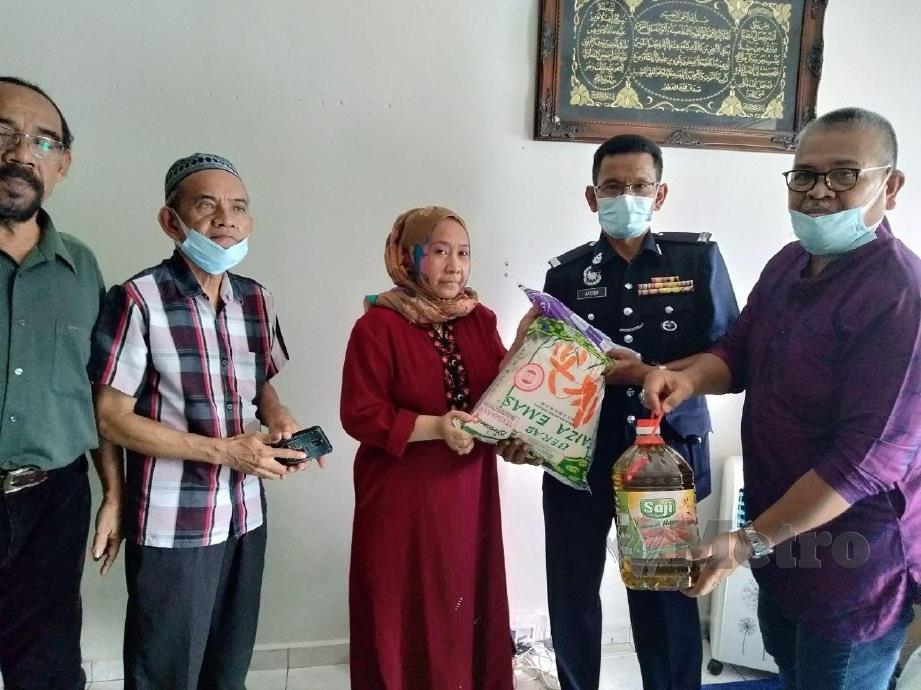 Rosilawati menerima sumbangan wang khairat kematian dan barangan keperluan dapur daripada Rose Afendi (dua dari kanan). FOTO Mohd Amin Jalil