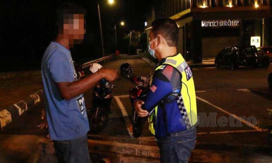 Anggota polis menahan seorang penunggang motosikal selepas hasil ujian pernafasan  mendapati dia positif mengambil alkohol daripada jumlah dibenarkan. FOTO IQMAL HAQIM ROSMAN