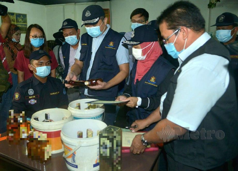 SZE Han (tengah) bersama pegawai serta penguat kuasa MPK melihat botol arak yang dirampas ketika operasi terjah peniaga warga asing di Lorong Kepayang, Klang. FOTO Faiz Anuar