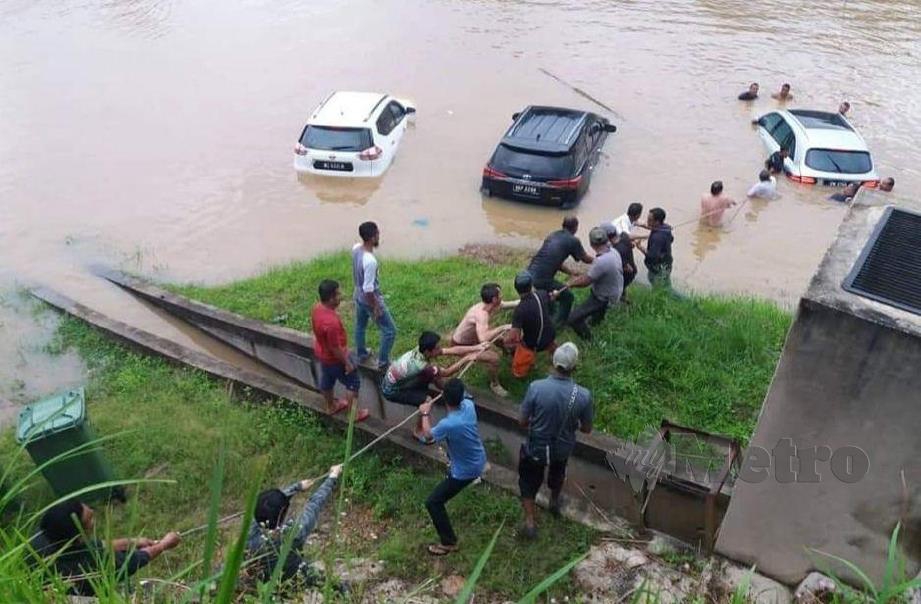 Penduduk Kuala Tahan  membantu menarik kenderaan yang tenggelam di pinggir sungai Tembeling, Taman Negara apabila air naik mendadak semalam. FOTO ROSELAN AB MALEK