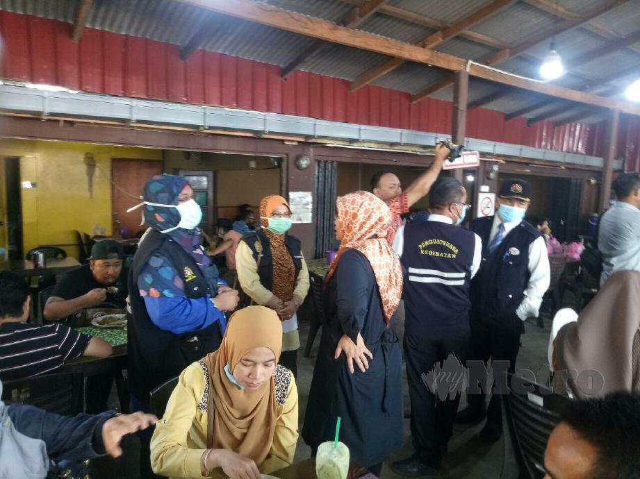 Pengarah Kesihatan negeri, Dr Nor Azimi Yunus (kiri) meninjau keadaan kedai makan pada operasi khas pemantuan SOP sekitar bandaraya Kuala Terengganu, hari ini. FOTO BAHAROM BAKAR