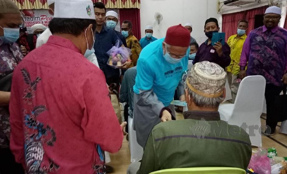 Datuk Dr Zulkifli menyantuni warga tua dengan sumbangan wang Hari Raya Aidil Adha pada Program YADIM Peduli Cuci-Cuci Dan Musa'adah Pasca Covid-19, di Kolej Universiti Darul Quran Islamiyyah, Kubang Lembik, Manir. FOTO ZAID SALIM
