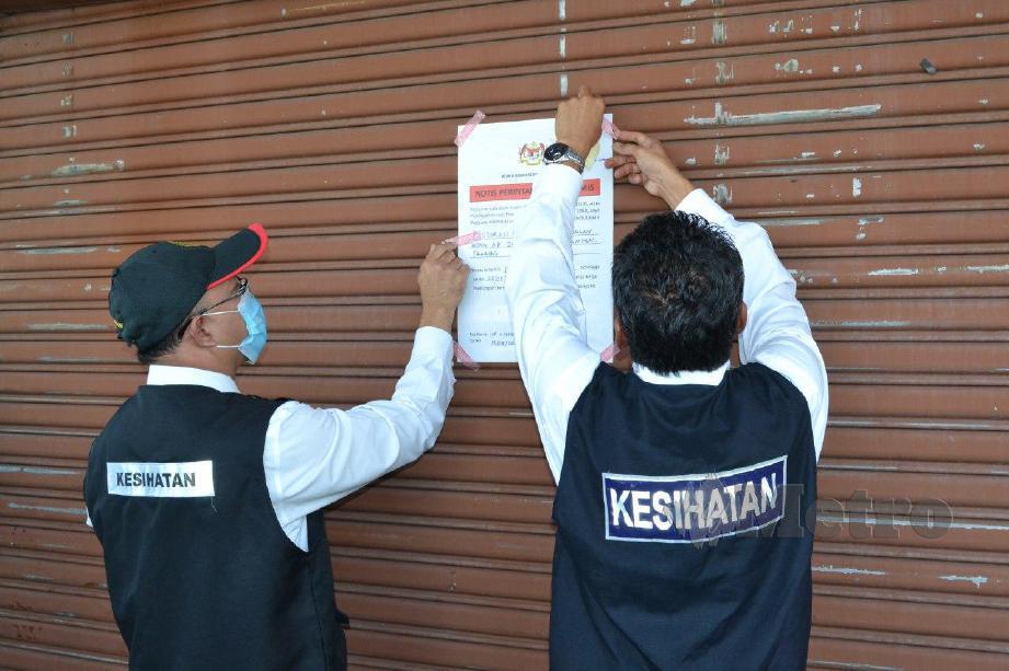 Pejabat Kesihatan Daerah Kuantan menampal notis penutupan premis di Kuantan. FOTO ASROL AWANG