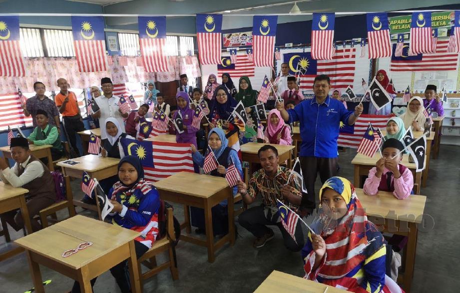 Murid Sekolah Kebangsaan Pulau Redang bersama guru dan pegawai Pejabat Pendidikan Daerah Kuala Nerus meraikan Pelancaran Mengibar Jalur Gemilang di sekolah berkenaan hari ini. FOTO Malik Muhamad