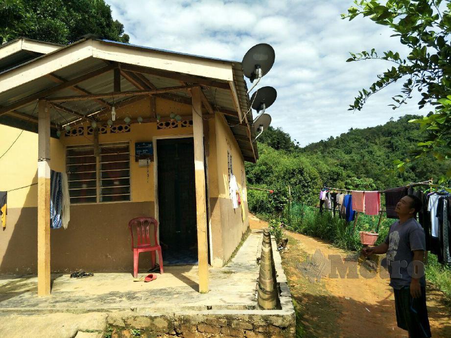 LIAN BUYONG menunjukkan rumahnya yang terpaksa menggunakan generator elektrik setiap malam untuk tempoh enam sahaja. FOTO RAMLI IBRAHIM