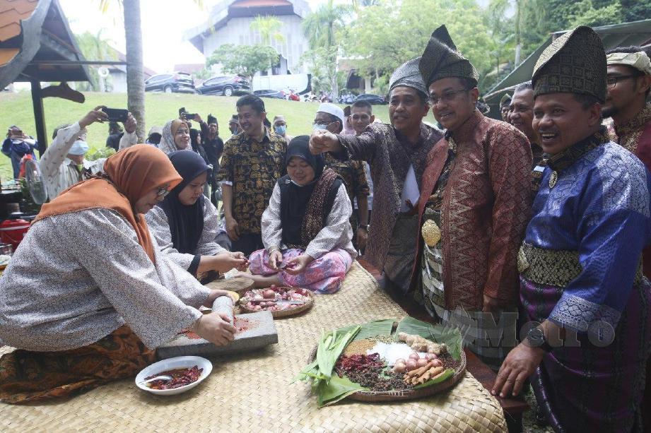 DR Ahmad Samsuri melihat demonstrasi cara pembuatan cili pada majlis pelancaran Kampung Budaya Terengganu (KBT), hari ini. FOTO Ghazali Kori