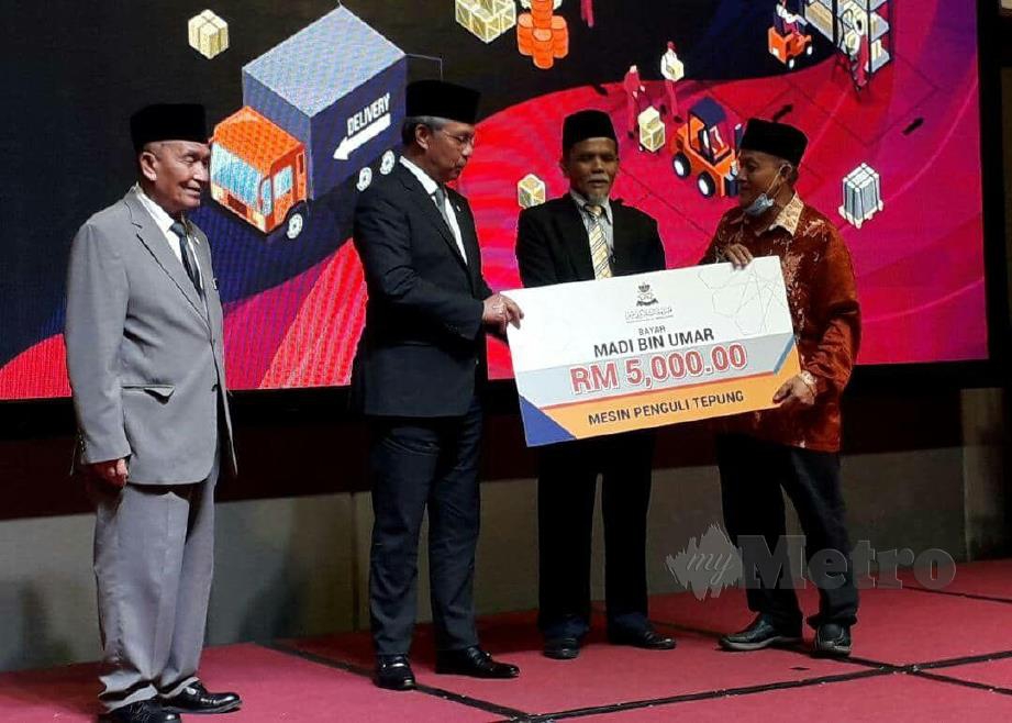 Menteri Besar, Datuk Hasni Mohammad bersama Tosrin Jarvanthi (kiri)  menyampaikan bantuan zakat kepada golongan asnaf. FOTO FARID NOH