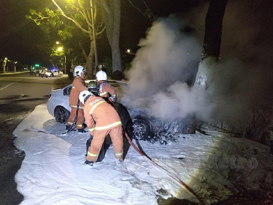 Pihak Bomba Tangga Batu berusaha memadamkan kebakaran sebuah kereta BMW. FOTO NAZRI ABU BAKAR