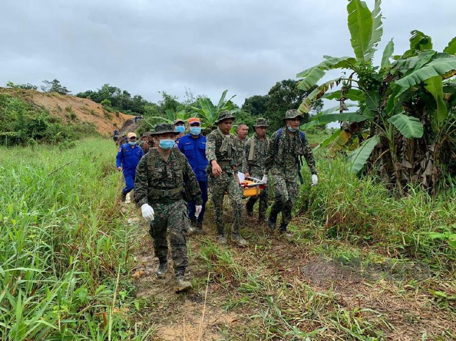 Pasukan SAR mengusung mayat mangsa yang ditemui di dalam hutan berhampiran pencawang elektrik Pan Borneo di Selalang, Bau pagi tadi. FOTO MELVIN JONI