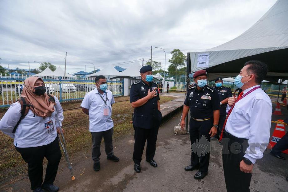 Tan Sri Abdul Hamid Bador (tengah) beramah mesra dengan pegawai SPR ketika tinjauan pengundian awal Ibu Pejabat Kontinjen Sabah sempena PRN Sabah 2020. FOTO ASWADI ALIAS.