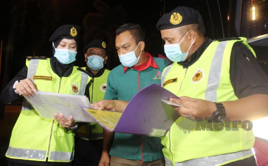 Pegawai Operasi JPJ Kelantan membuat pemeriksaan bagi mengesan kesalahan yang dilakukan pemandu bas ekspress ketika pemantauan sempena Op Penguatkuasaan Khas JPJ 2020 di Terminal Bas Lembah Sireh. FOTO NIK ABDULLAH NIK OMAR