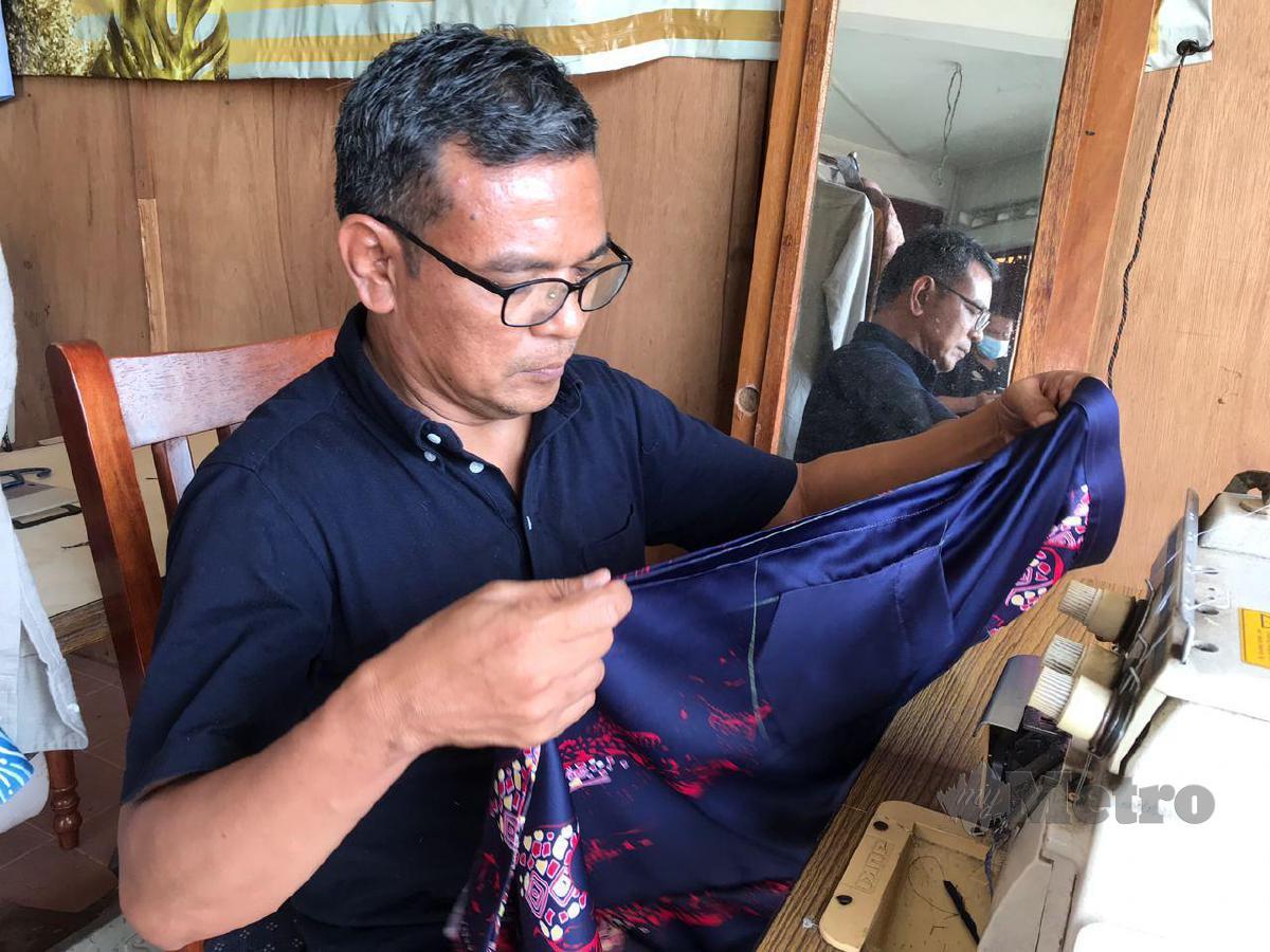 CHE  Sabri Che Jaafar menyiapkan tempahan baju pelanggannya. FOTO Hazira Ahmad Zaidi