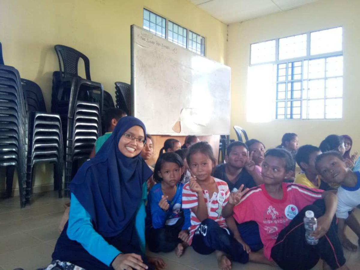 KENANGAN Nurul Afifah Aiman (kiri) ketika program menghulurkan bantuan kepada anak-anak Orang Asli.