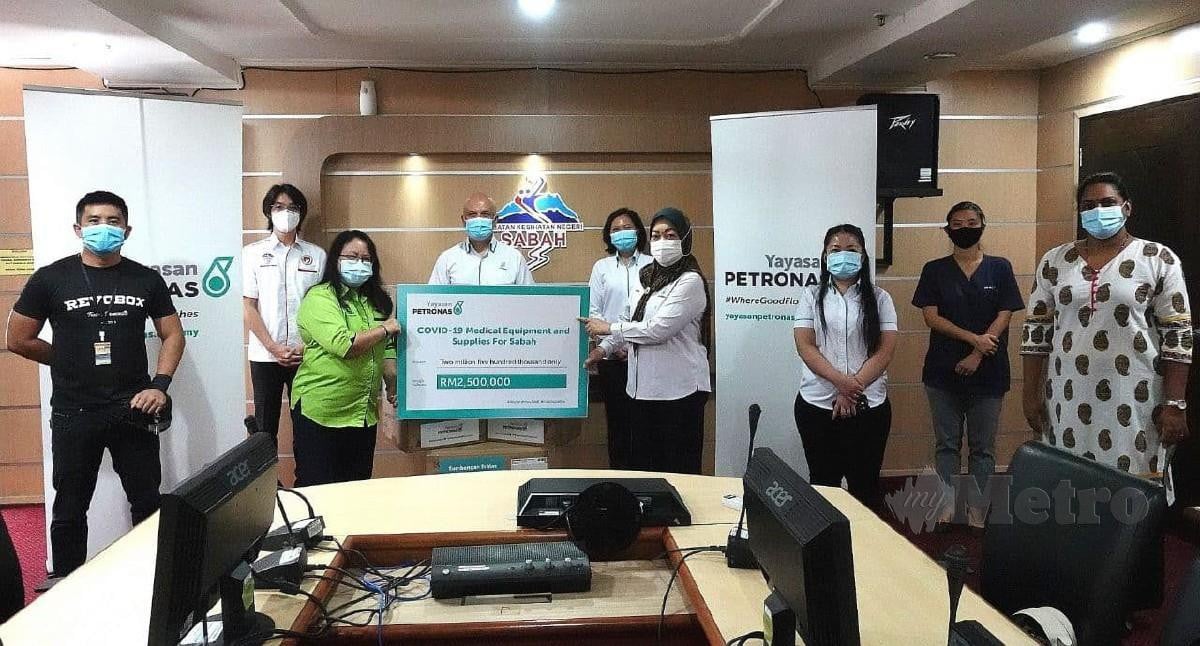 ROKIAH (empat kanan) menyerahkan bekalan perubatan untuk diagihkan kepada hospital dan klinik di Sabah kepada Dr Christina (tiga kiri). FOTO Ihsan Yayasan Petronas