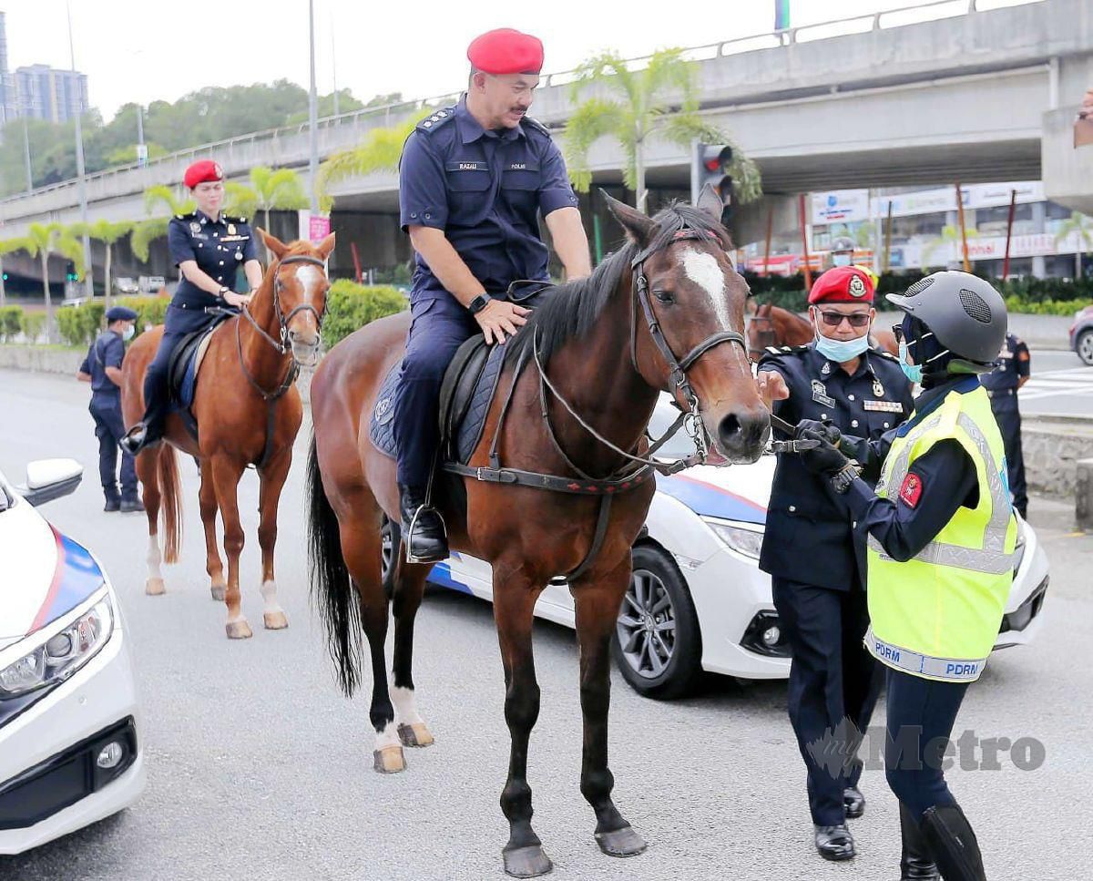 Razali mencuba menunggang kuda pada Rondaan Unit berkuda PDRM di Pusat Bandar Puteri, Puchong. FOTO Saifullizan Tamadi.