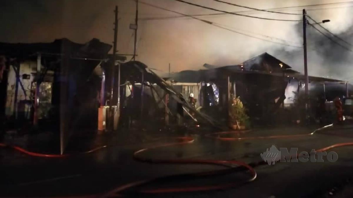 ANGGOTA bomba memadamkan kebakaran membabitkan empat premis terdiri daripada rumah dan kedai di Kampung Baru Ampang. FOTO Ihsan Bomba