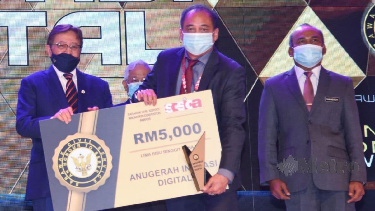 Datuk Patinggi Abang Johari Abang Openg menyampaikan hadiah kepada salah seorang pemenang pada Anugerah Konvensyen Inovasi Perkhidmatan Awam Sarawak (SCSICA) 2020, hari ini. FOTO IHSAN JABATAN PENERANGAN